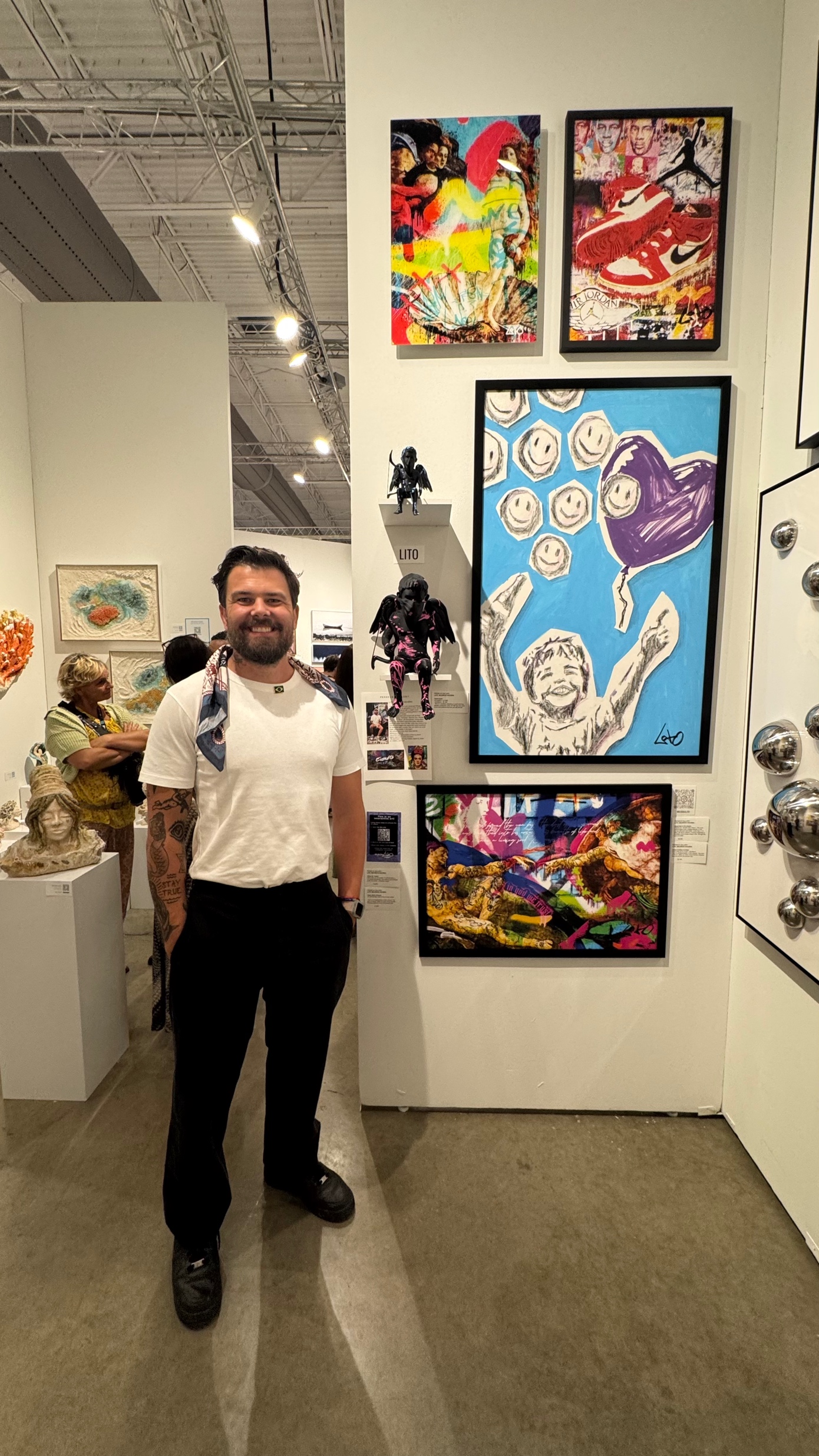 Lito ao lado de suas obras na exposição em Miami